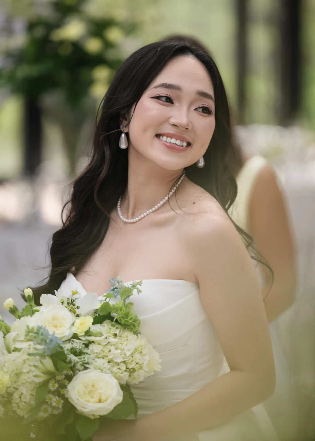 Robbie & Hannah's Wedding @ Edinburgh West, Taylors SC: Smiling bride in a strapless white gown holds a bouquet of white and pale green flowers.