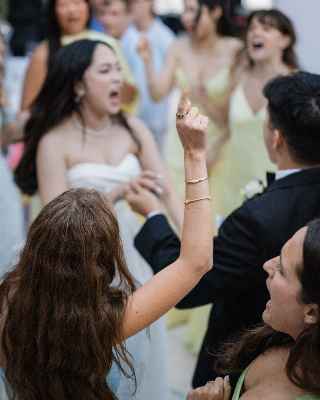 Robbie & Hannah's Wedding @ Edinburgh West, Taylors SC: Wedding guests cheer and dance around the bride in a white dress and groom in a black suit.