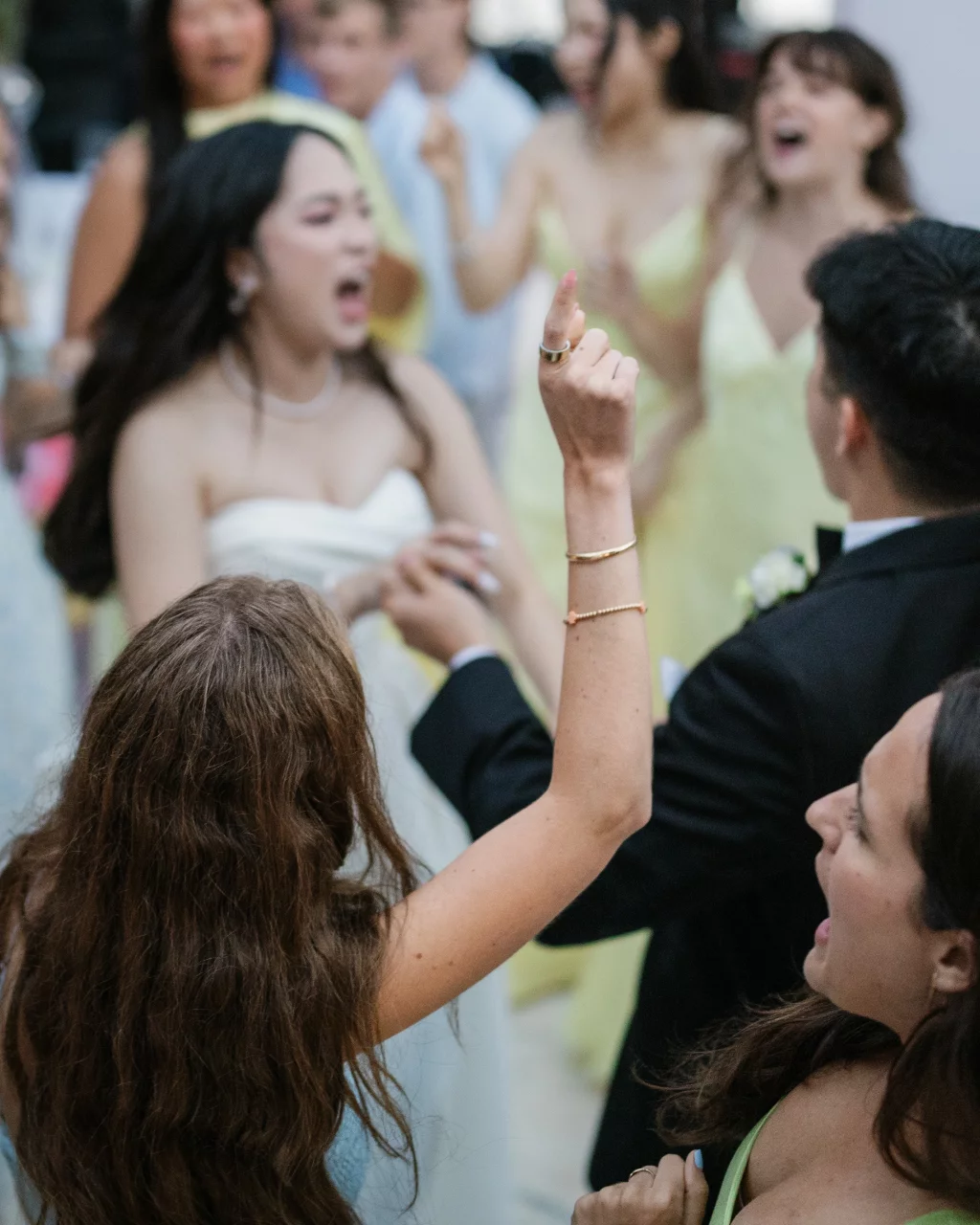 Robbie & Hannah's Wedding @ Edinburgh West, Taylors SC: Wedding guests cheer and dance around the bride in a white dress and groom in a black suit.