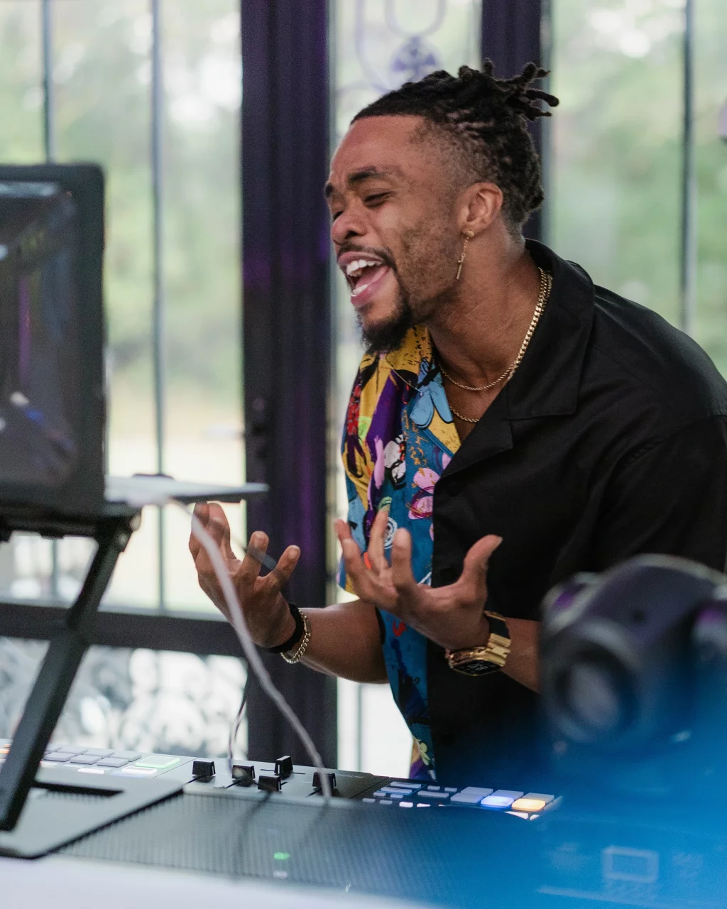 Robbie & Hannah's Wedding @ Edinburgh West, Taylors SC: DJ with dreadlocks gesturing energetically behind a music console at a wedding reception.