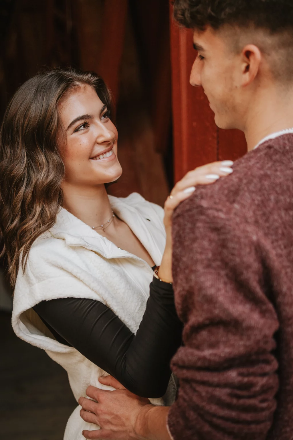 Ethan & Savanah's couple photo session taken at Campbell's Covered Bride, Greenville County: Young woman smiling at a young man while holding his shoulders, both standing close together indoors.