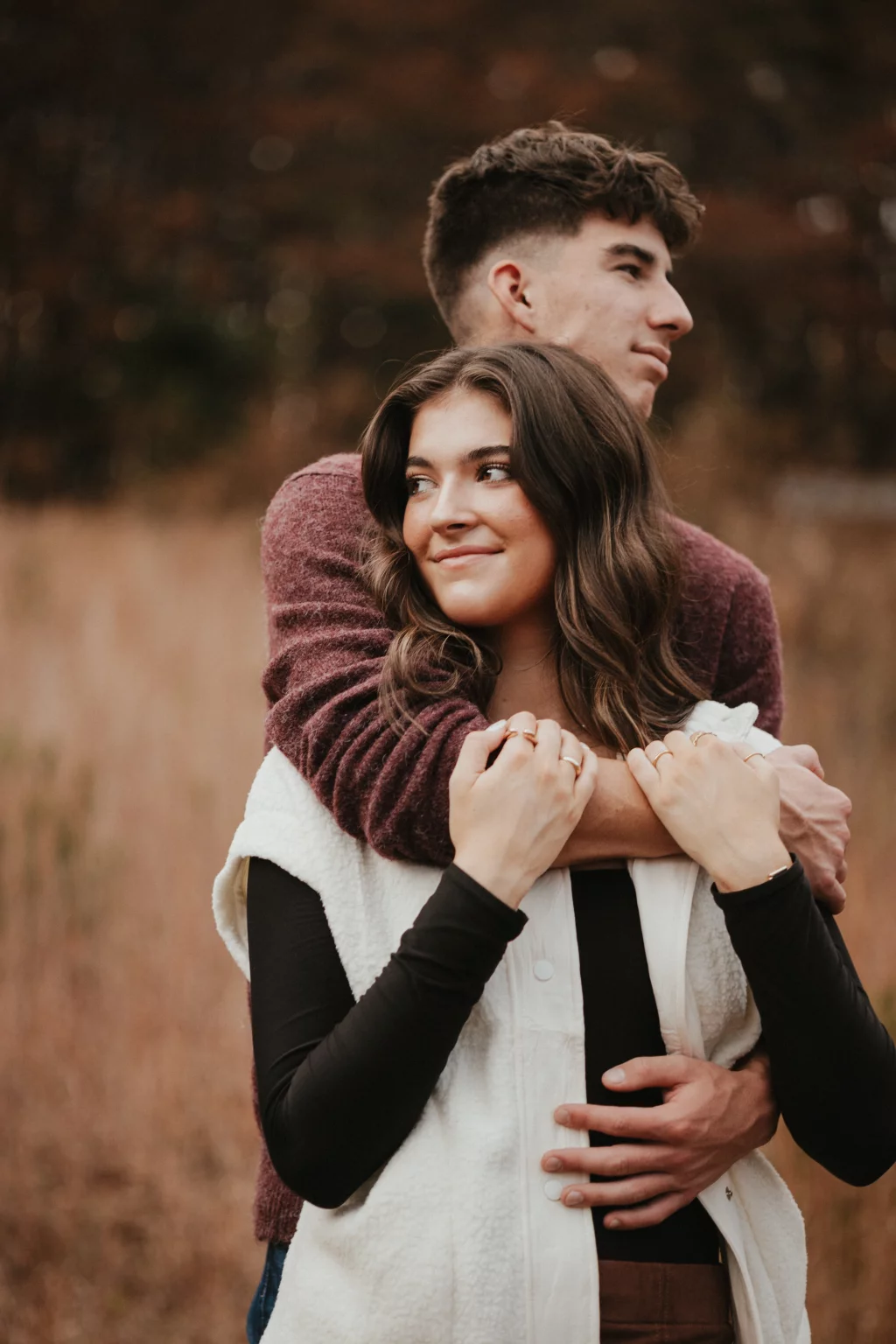 Ethan & Savanah's couple photo session taken at Campbell's Covered Bride, Greenville County: Young couple hugging in an outdoor autumn setting with blurred brown foliage background.
